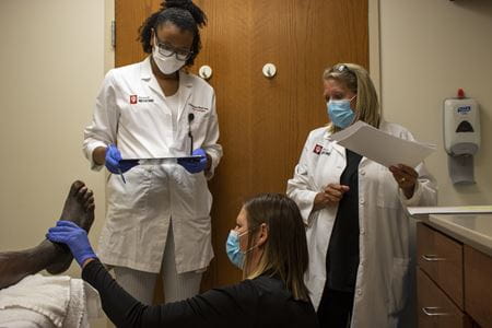 Comprehensive Wound Care Center Staff inspect patient's foot
