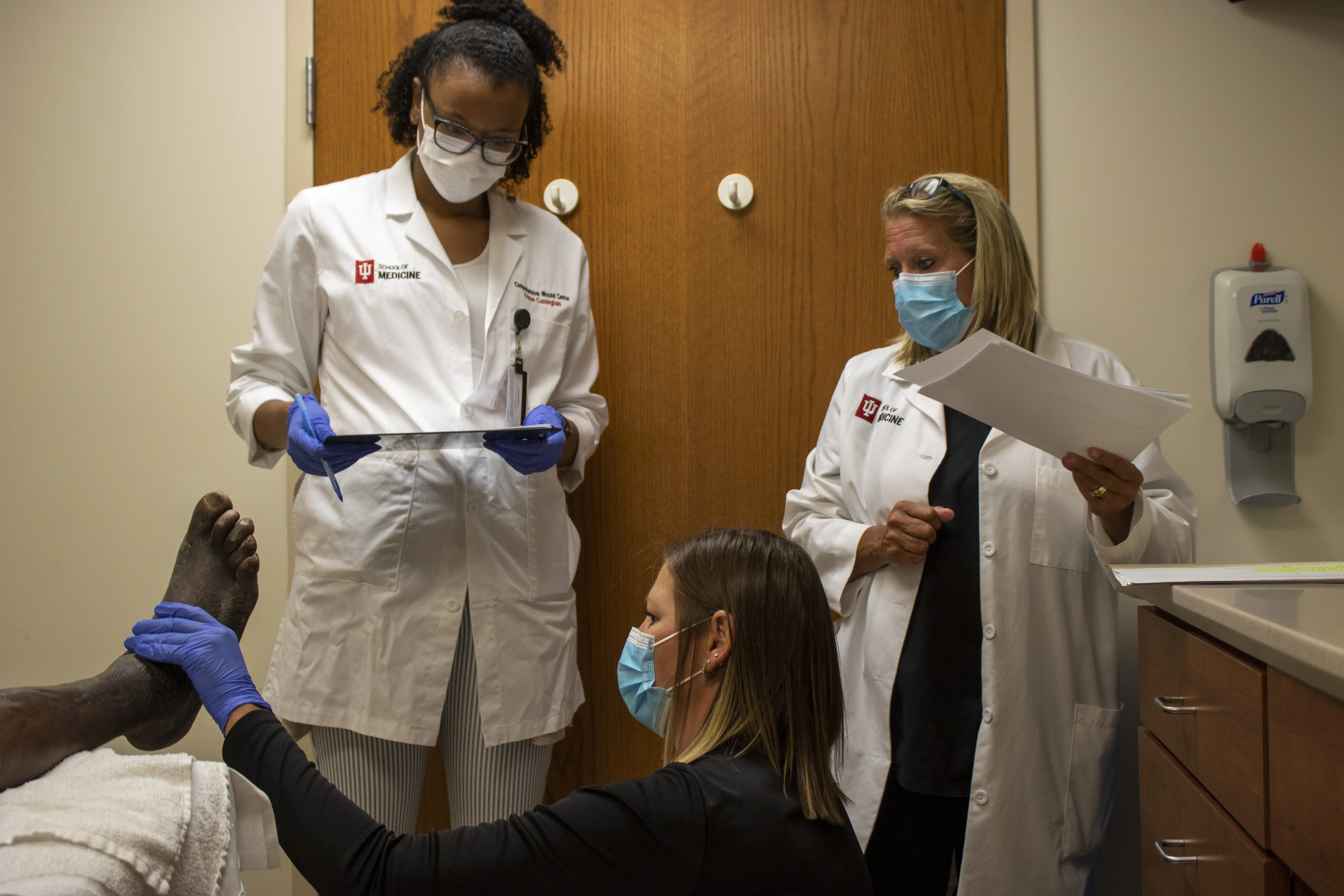 Comprehensive Wound Care Center Staff inspect patient's foot