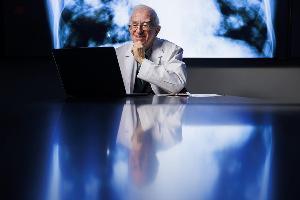 larry einhorn sits at a desk reviewing imaging scans