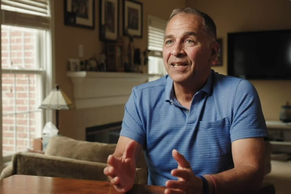 greg tamer speaks in his living room