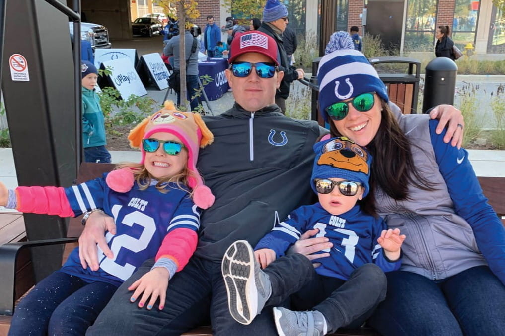 The Pemberton family dressed in Colts gear sit outside on a fall day