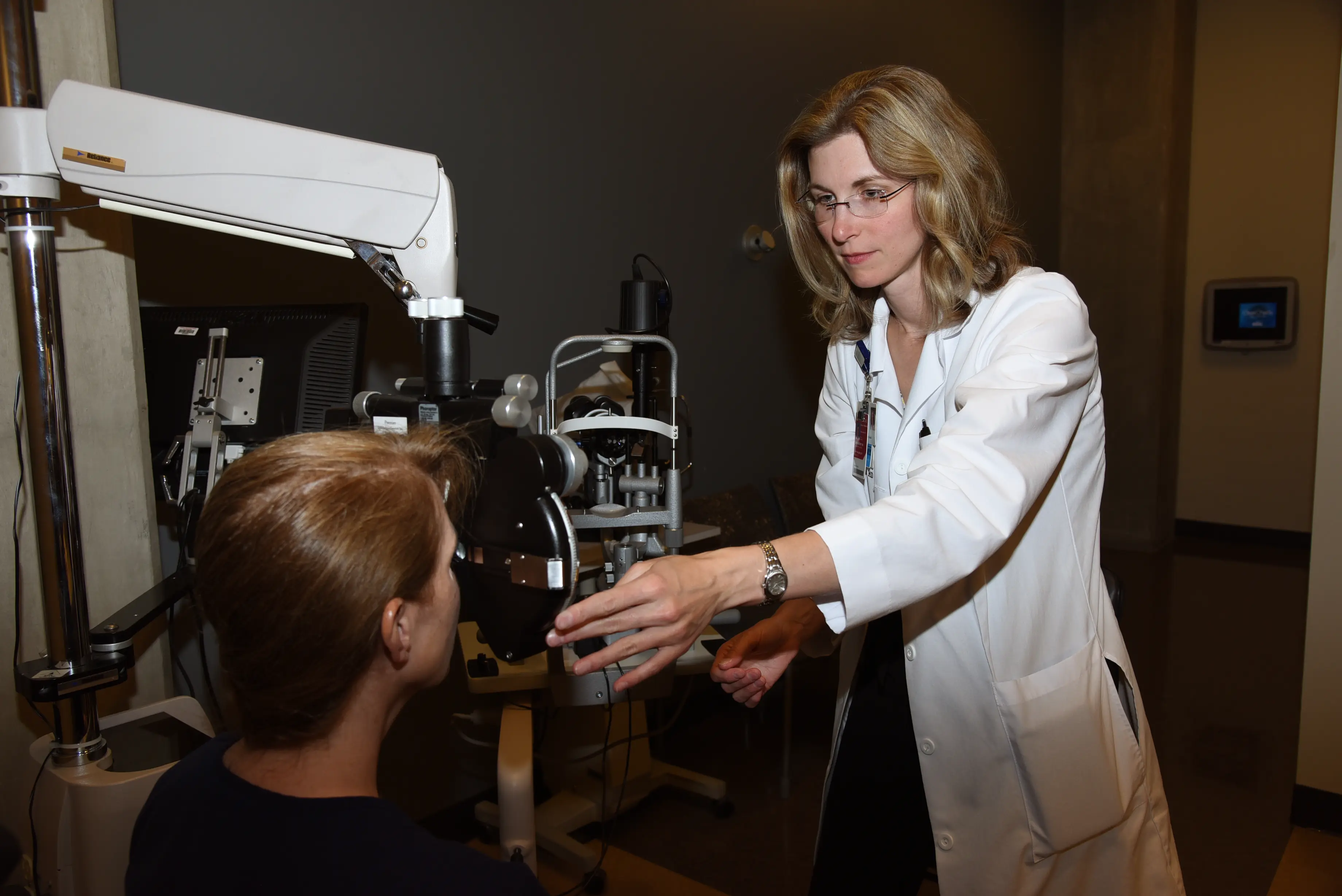 Jennifer Eikenberry, MD, of the Department of Ophthalmology works in a clinical exam room with a patient