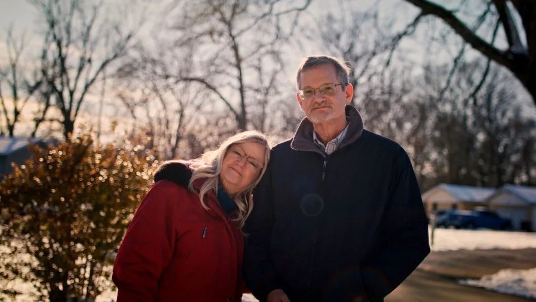 Bill Svihla and his wife stand together outside on a sunny winter day