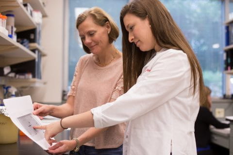 Two researchers review data together in the lab.