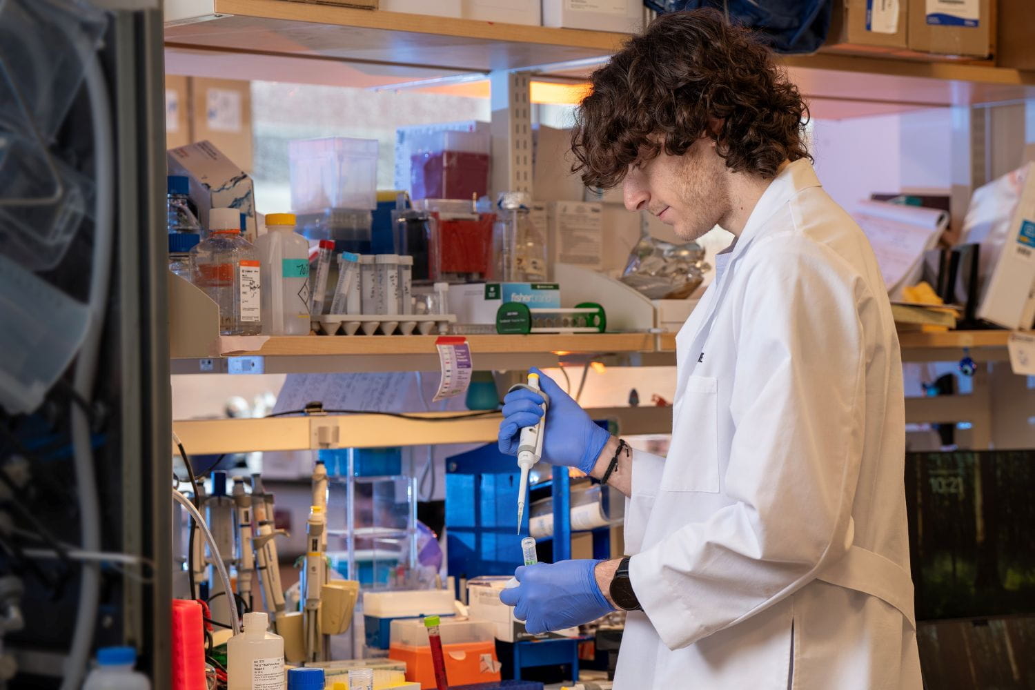 A male student pipetting liquid into a test tube.