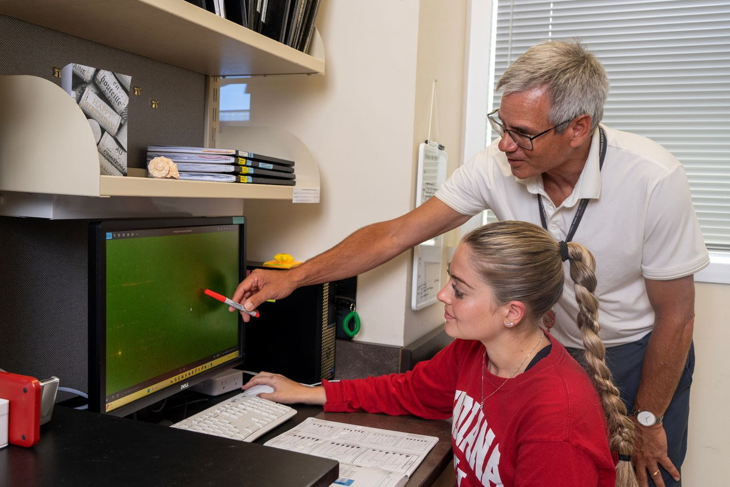 John Turchi and a student from his lab review data on a computer monitor.