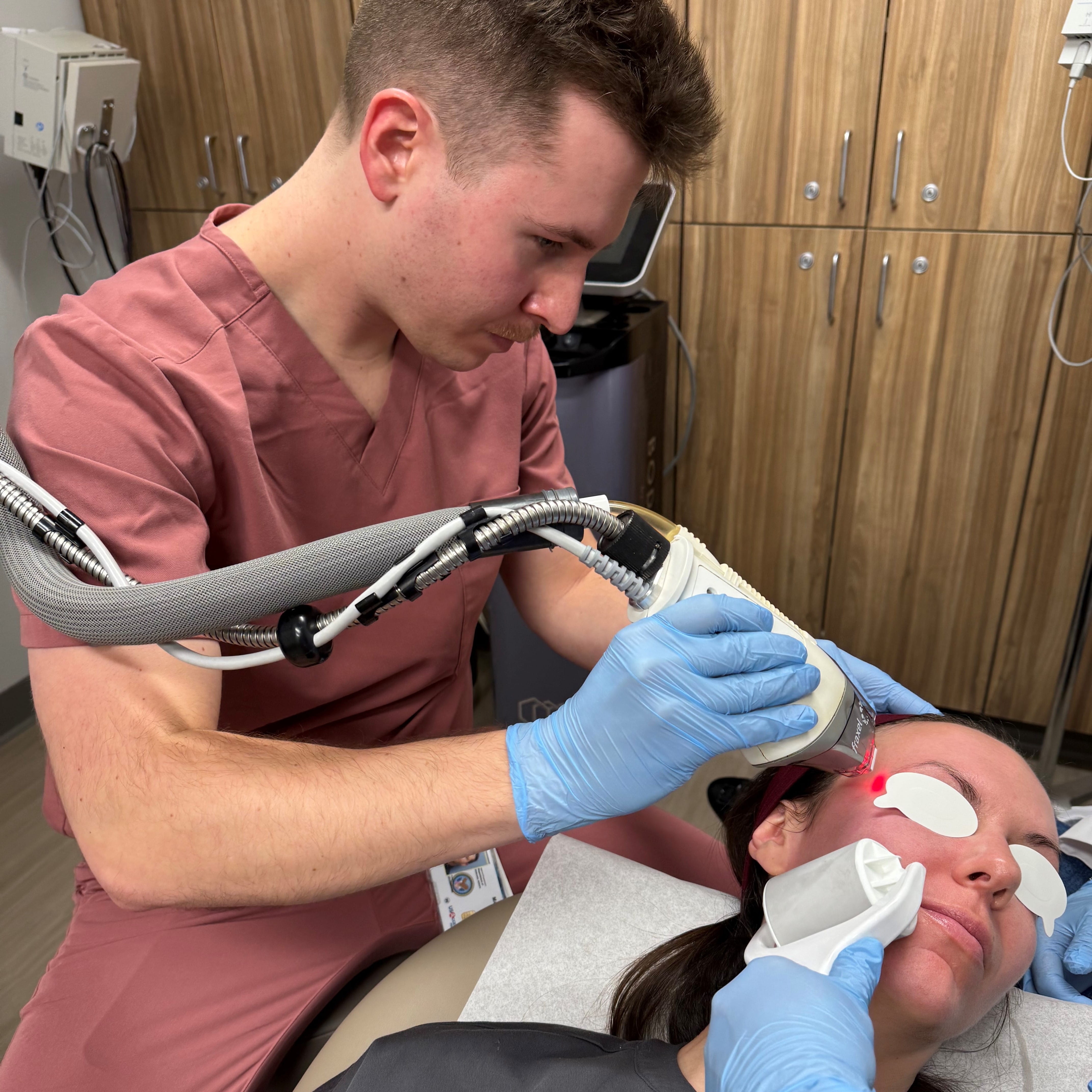 Dermatology Resident Aaron Peach performing laser treatment on a patient