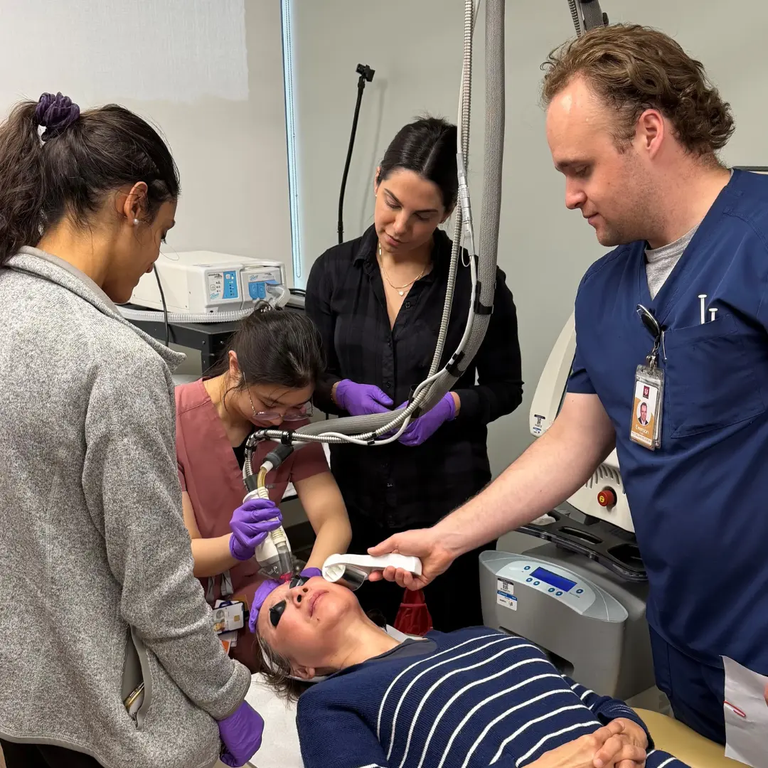 Dermatology Residents Ruple Jairath, Collin Evenson, Tiffany Cheng, and Cosmetics Director Janelle Nassim using the cosmetic laser on a patient in clinic