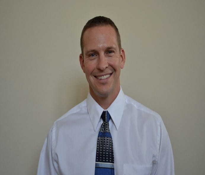 Headshot of man in white short with tie