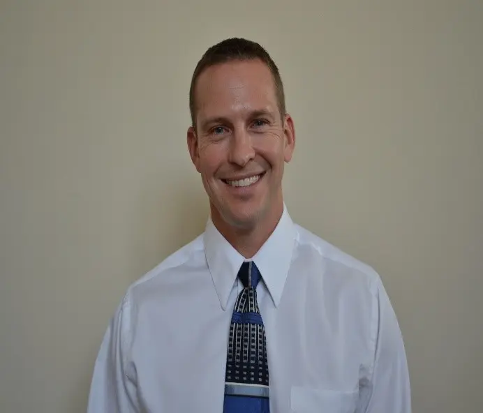 Headshot of man in white short with tie