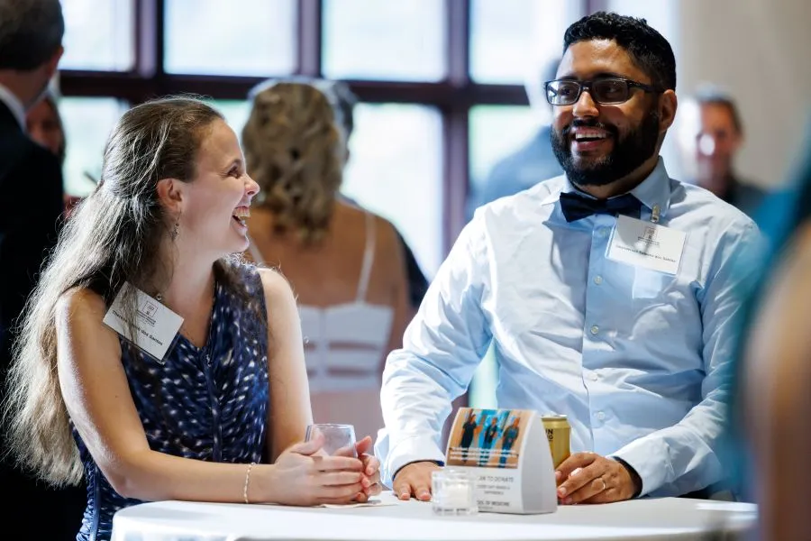 two people laugh and talk at the gala