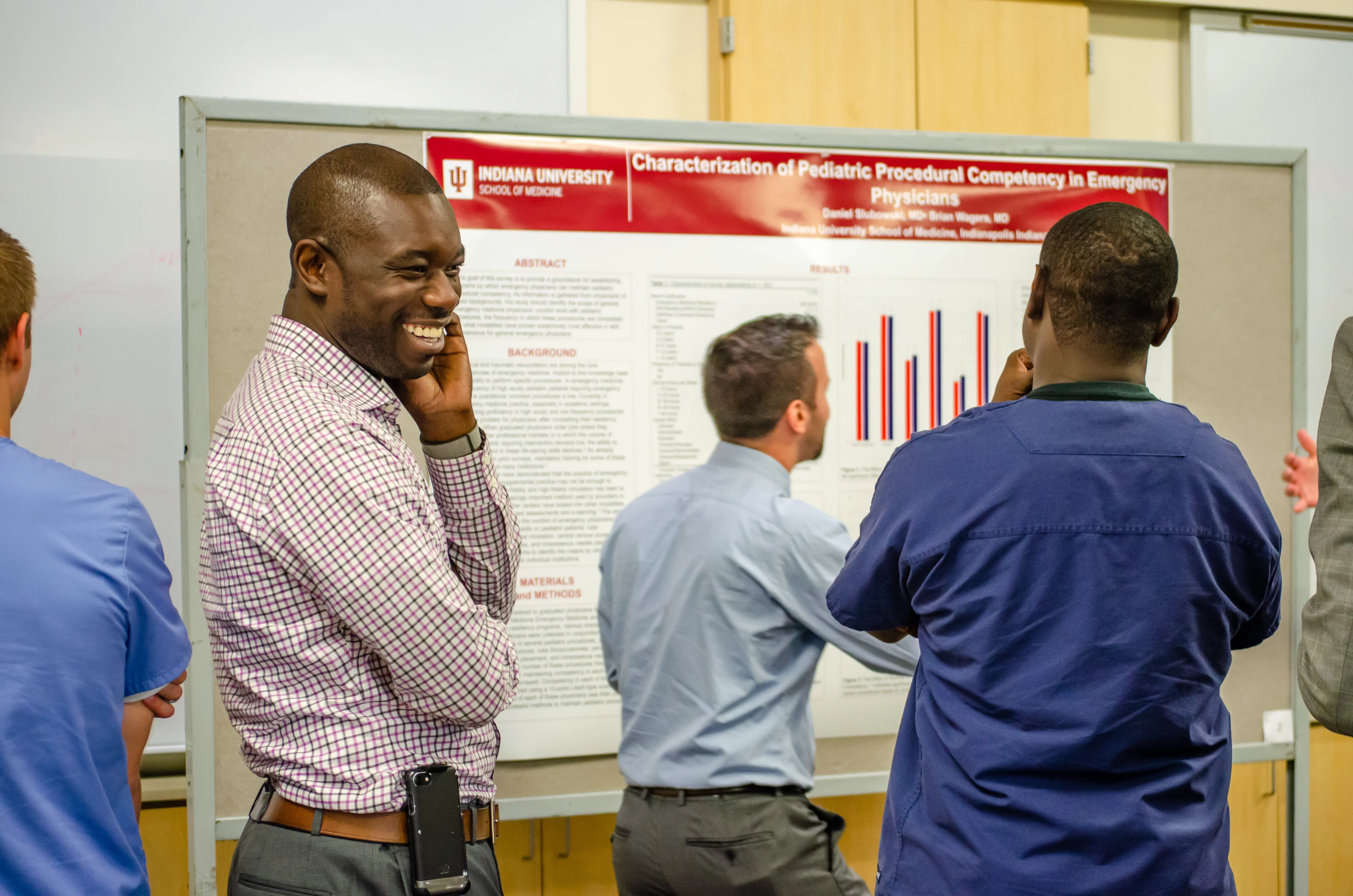 Faculty, including Dr. Ben Nti, at a research poster presentation. 
