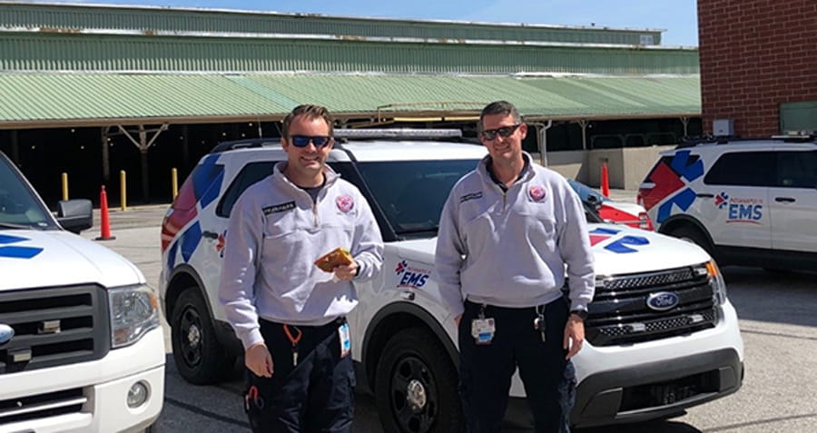 Two ems providers in front of their vehicles