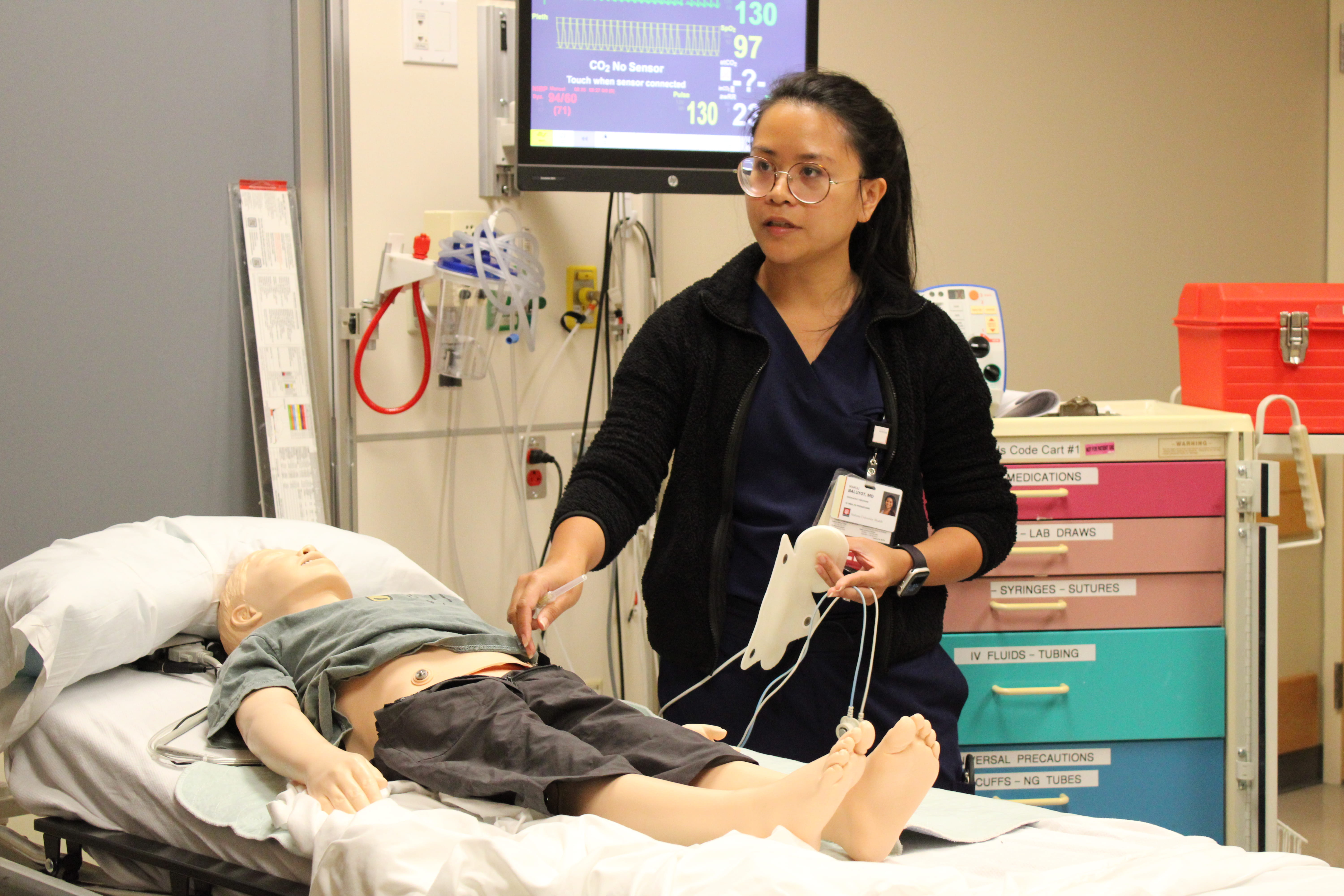 Dr. Baluyot demonstrates emergency care on a simulation pediatric patient mannequin.