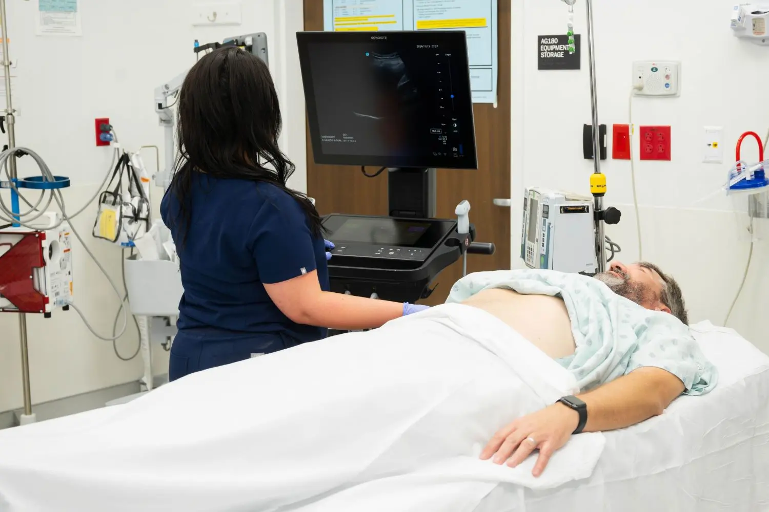An individual performs ultrasound on a patient in the emergency department. 