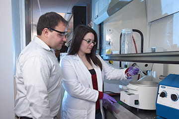 two researchers look at a sample in the Kline lab
