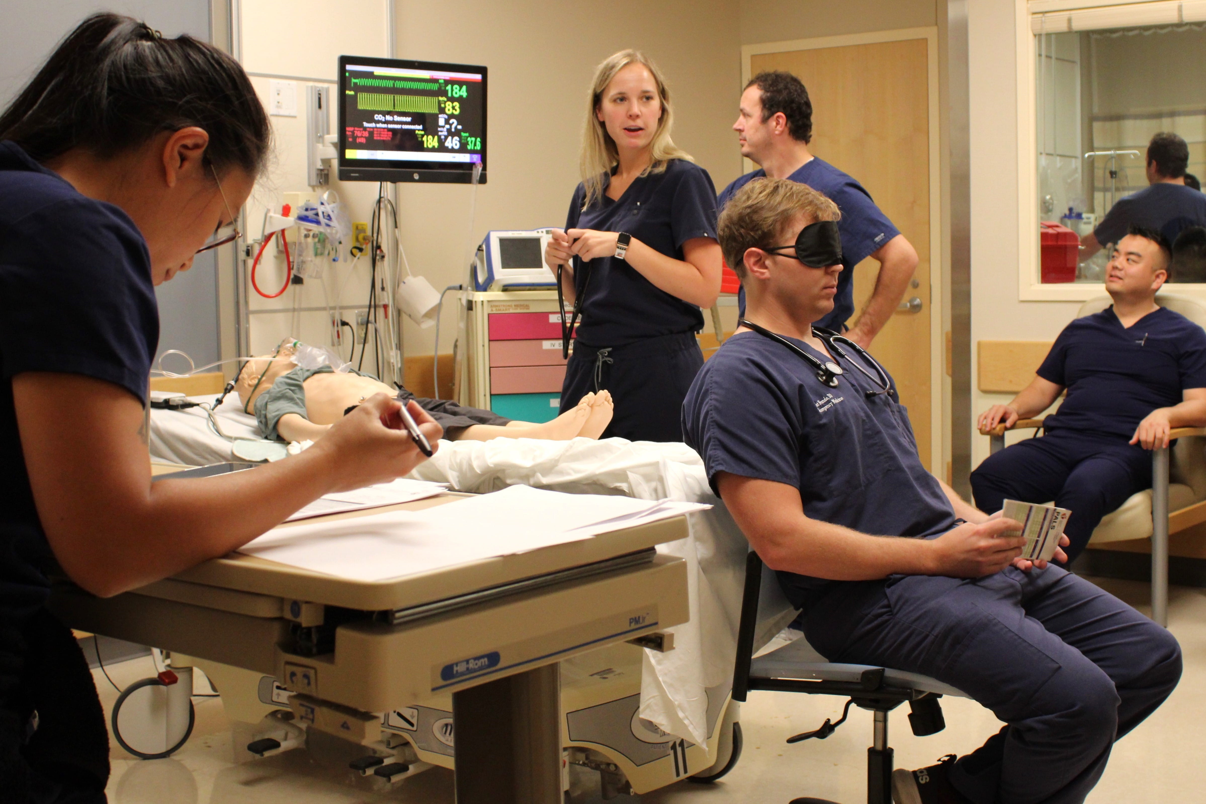 two fellows train with a manikin