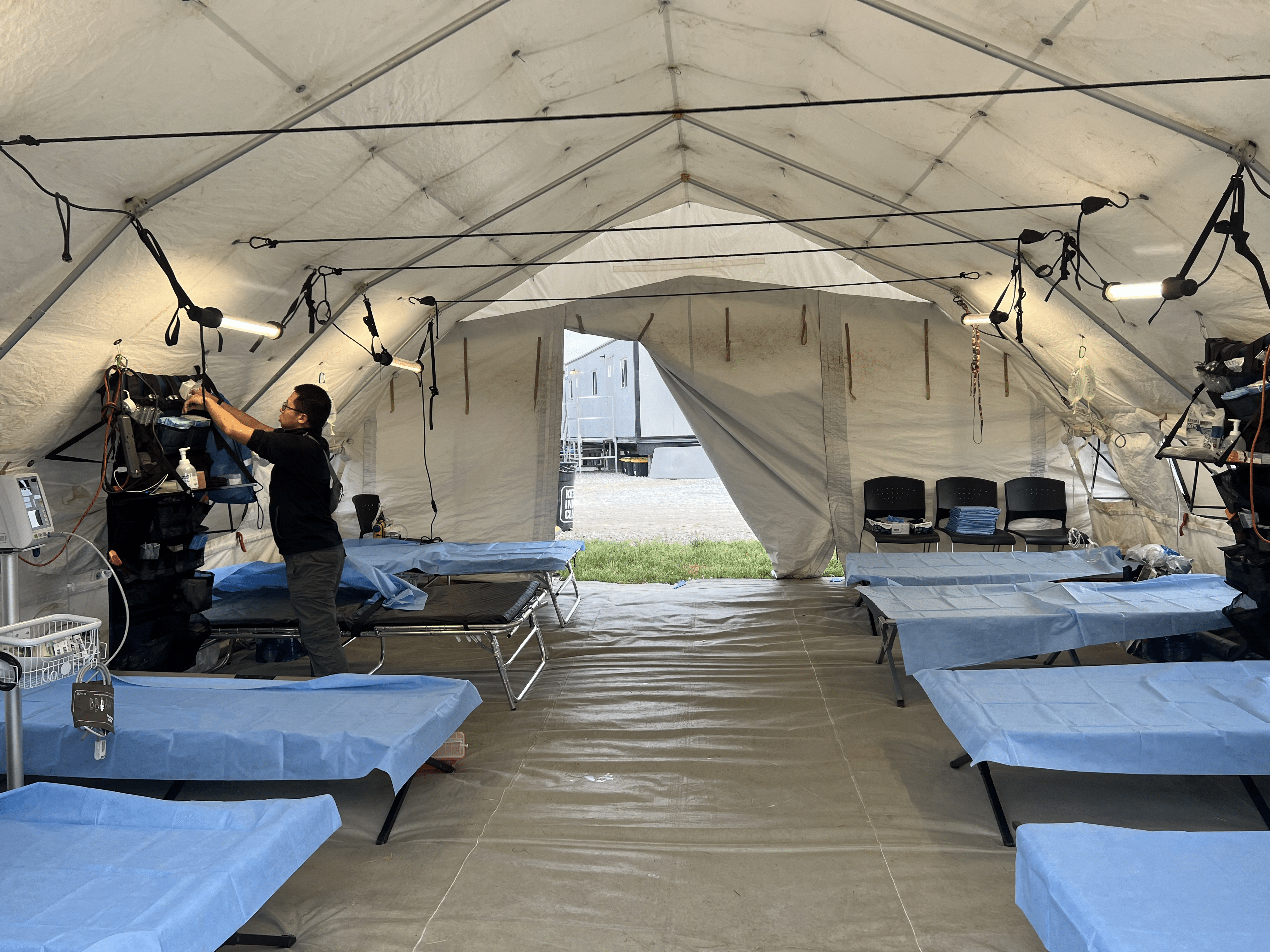 oxicology fellow setting up equipment in a patient tent.