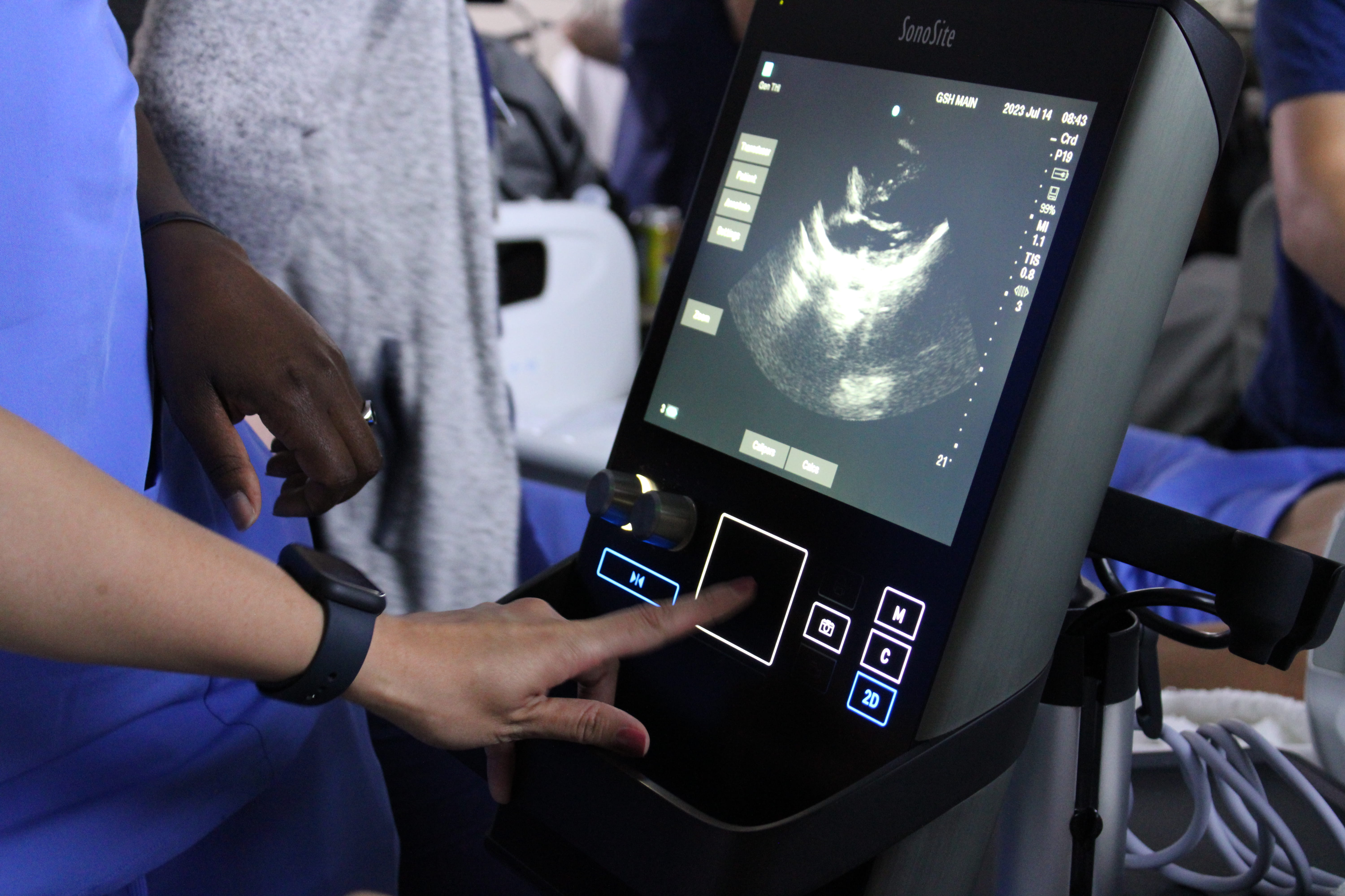 A person conducting an ultrasound and pointing to the screen. 
