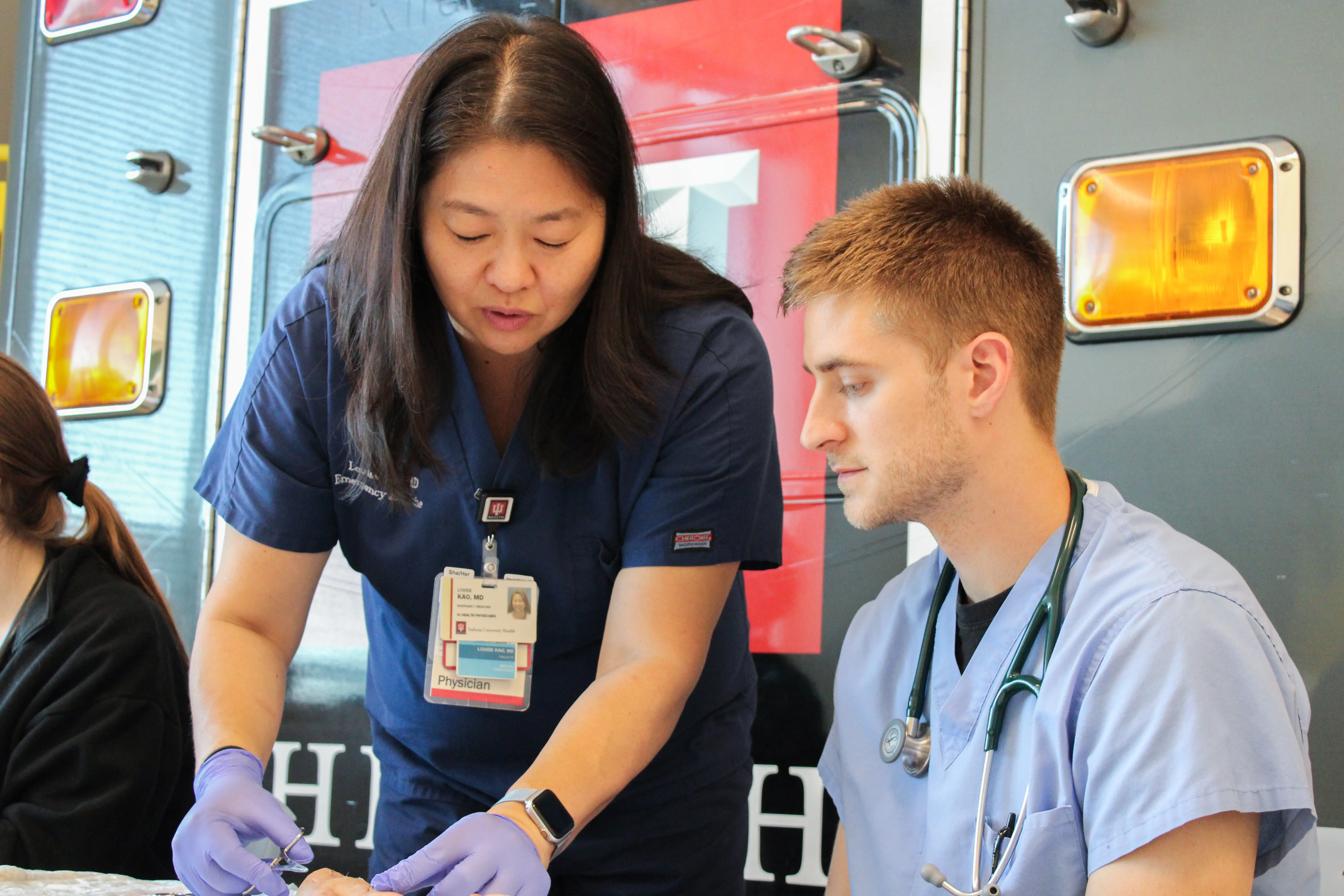 Dr. Louise Kao demonstrates suturing to a medical student. 