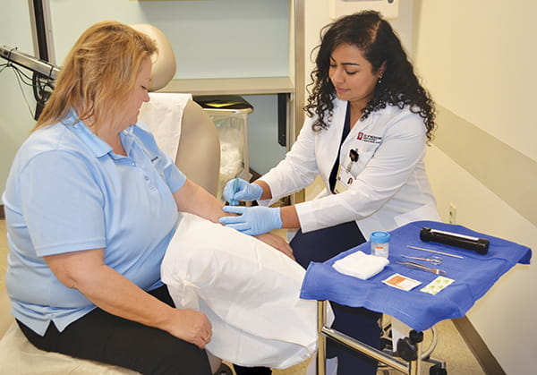 a family medicine resident examines the arm of a patient in the clinic
