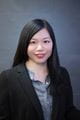 esther chang wearing a black jacked over a grey shirt. she has long straight black hair.