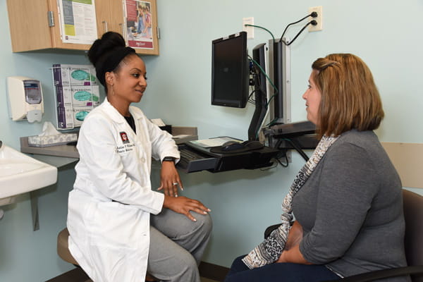 a resident speaks with a patient in the clinic