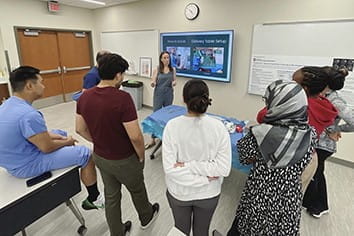 residents listen to a faculty member speak in clinic