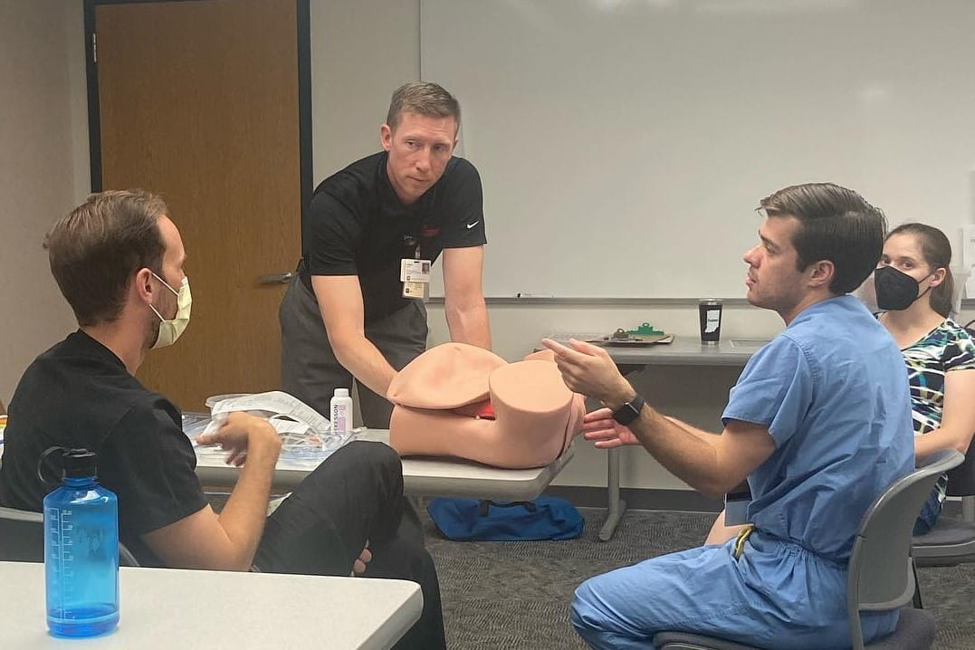 a faculty member instructs residents on an anatomical model