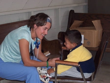 Kelly Givler Berkram talks with a young boy before giving him an exam.