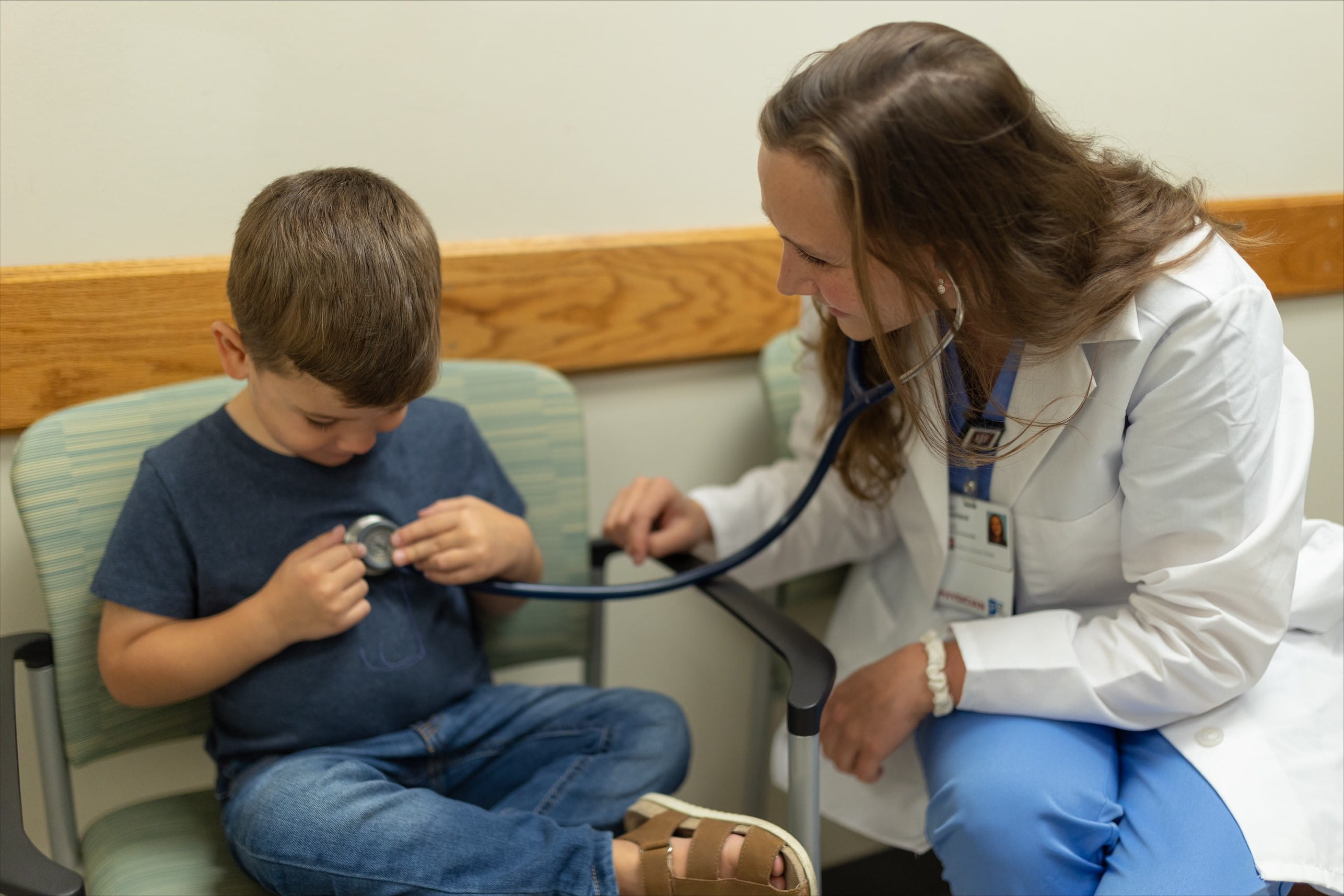 a resident uses a stethoscope to listen to a child's breathing