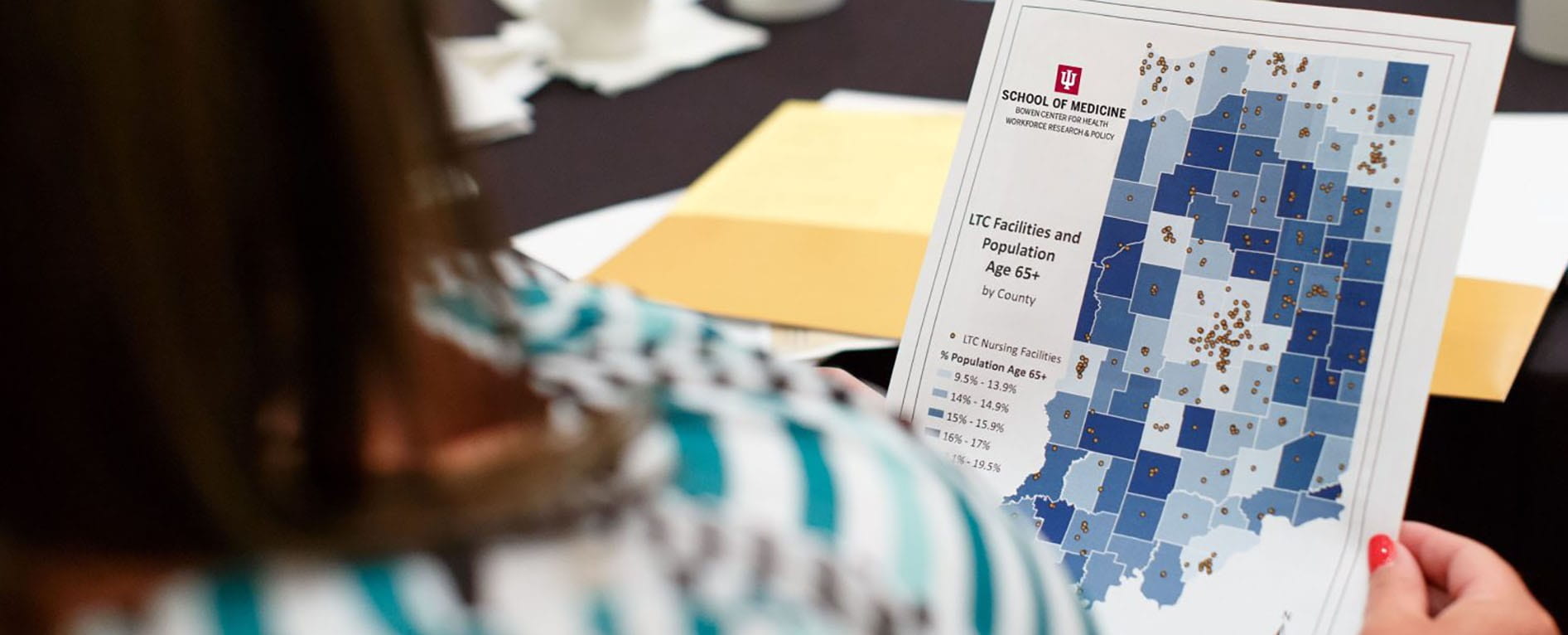 a person with long hair holds a map of indiana showing long term care facilities