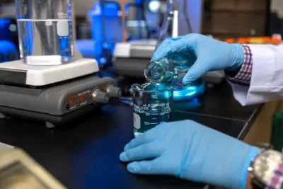 a close up photo of gloved hands preparing a research sample
