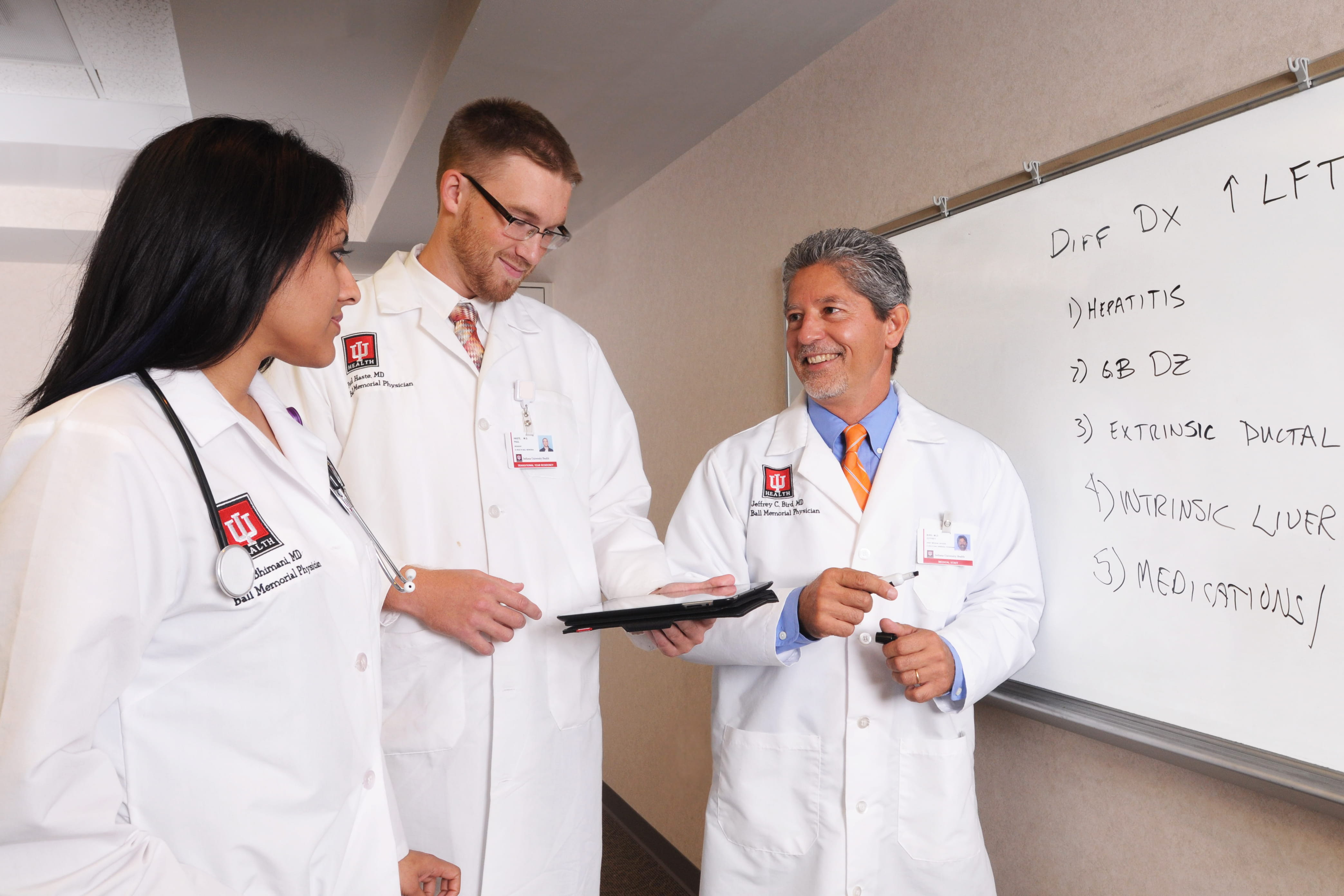 residents and faculty discuss notes written on a whiteboard