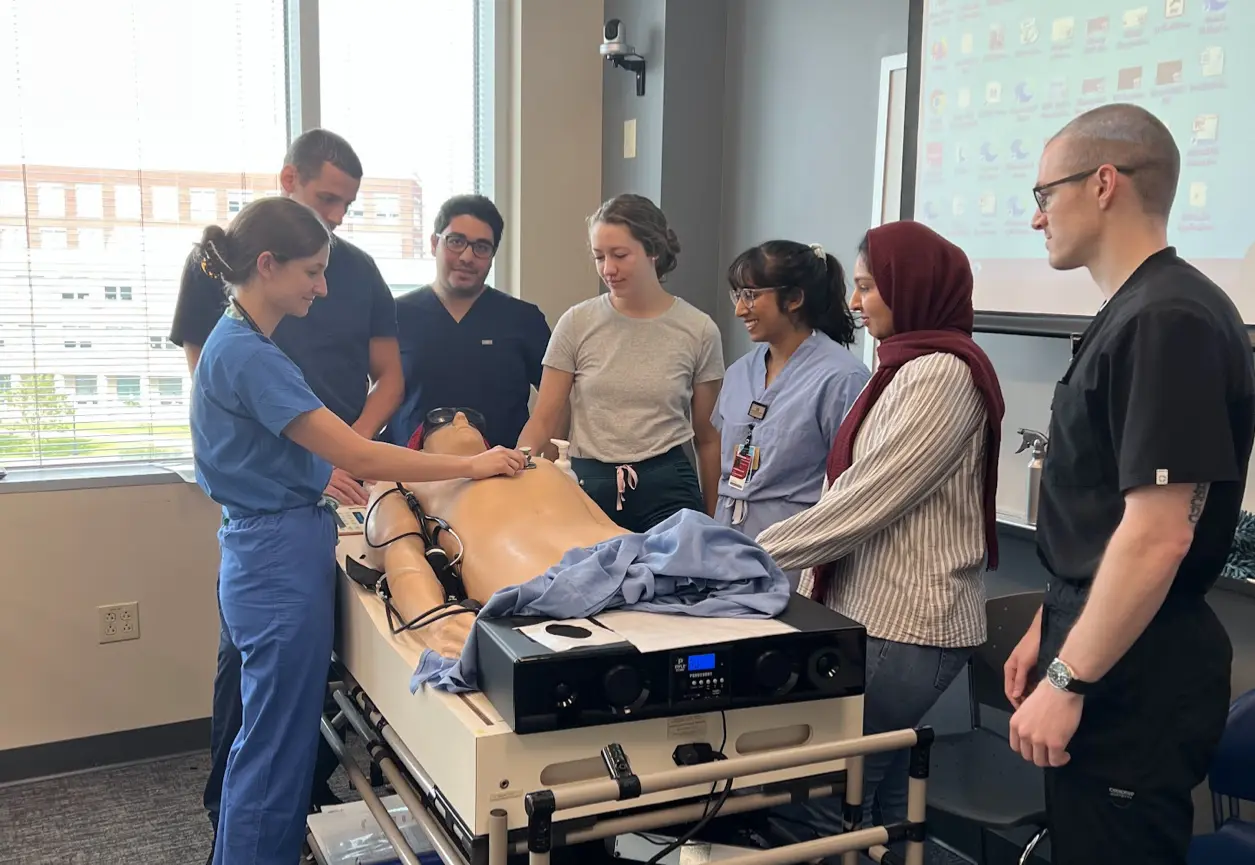 A group of residents gathered to learn a procedure.