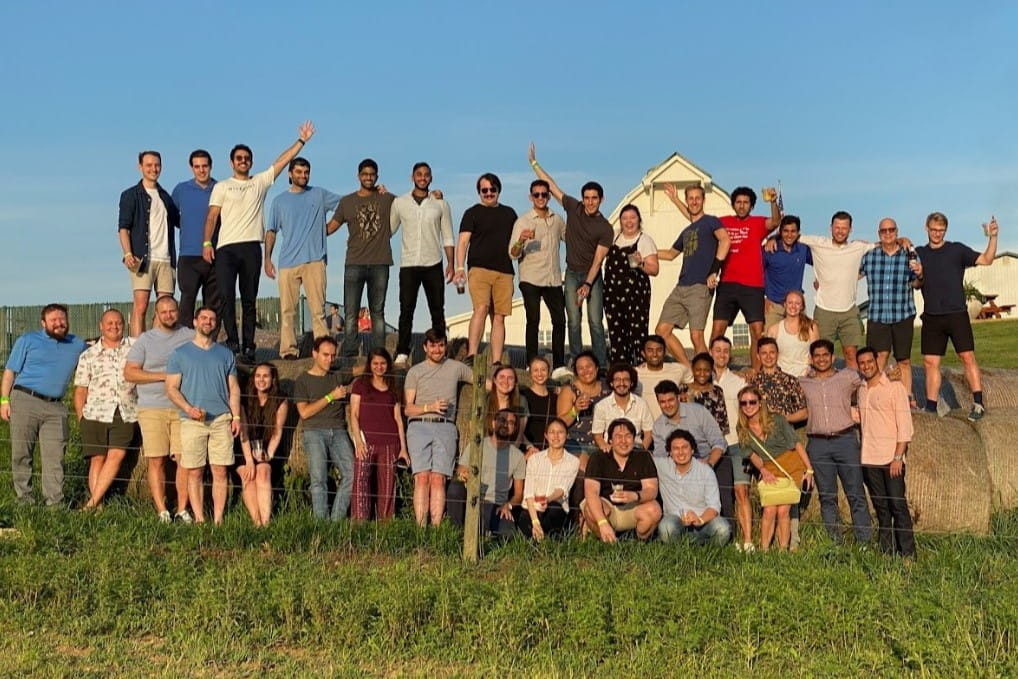 residents stand on huge hay bales at the internal medicine residency retreat