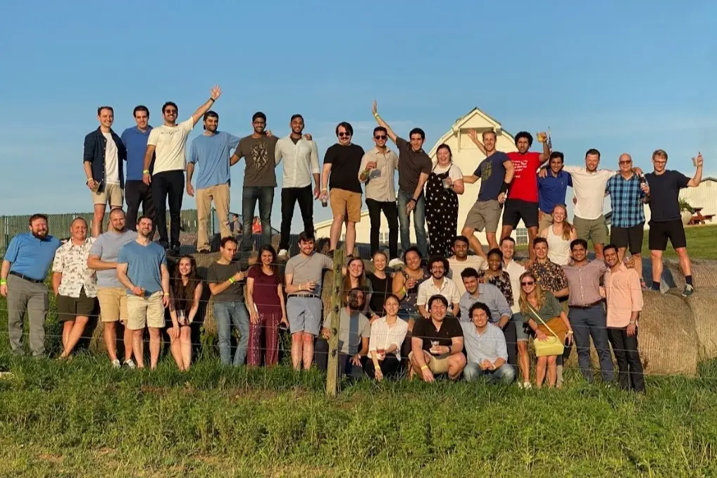 residents stand on huge hay bales at the internal medicine residency retreat