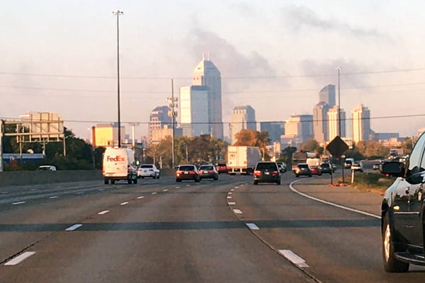 the skyline of indianapolis is visible from the highway