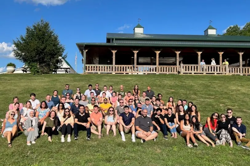 large group of internal medicine residents sitting on a sloping lawn
