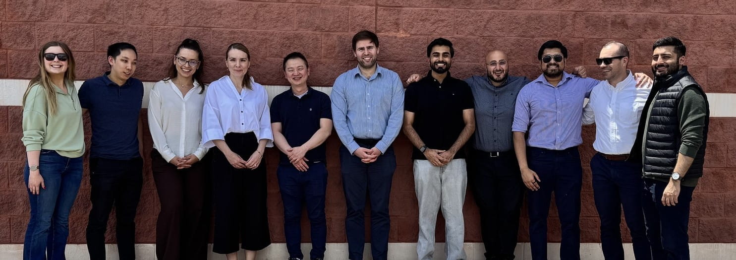 Residents with Program Director, standing against a brick wall.
