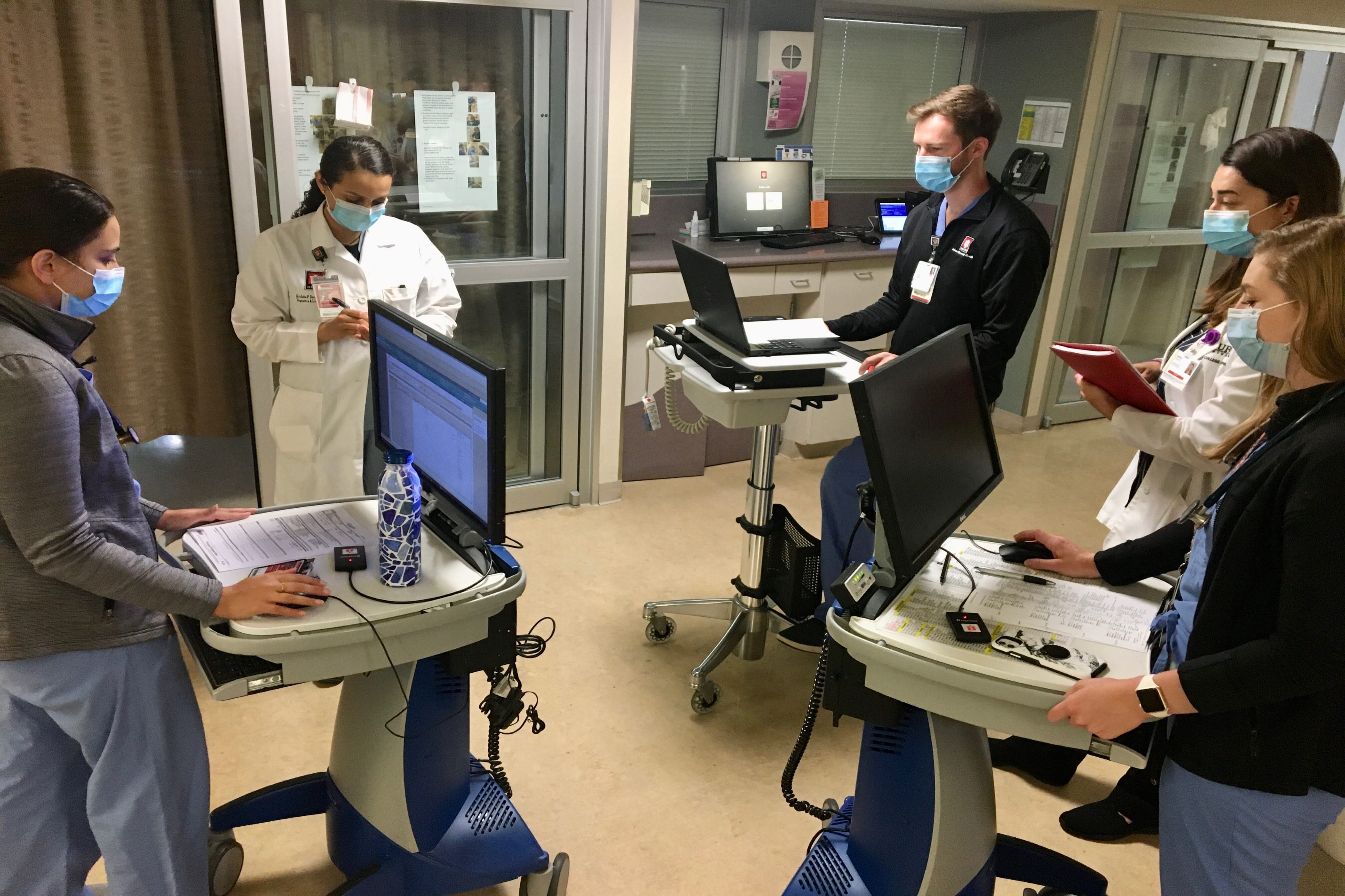 a group of physicians consult together in the hospital during rounds