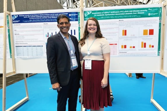 Picture of Naga Chalasani and Kaela Miller at EASL 2025 standing in front of research posters smiling.