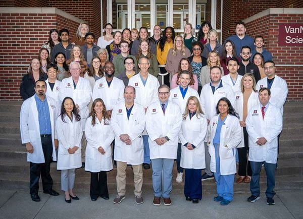 Group photo of the Division of GI and Hepatology smiling on the steps of the Med Science building.