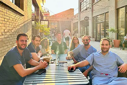 Photo of our group of fellows sitting outside a taco restaurant smiling.