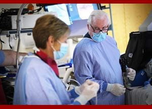 Photo of Dr. Lehman in the endoscopy suite during a procedure talking to a colleague.