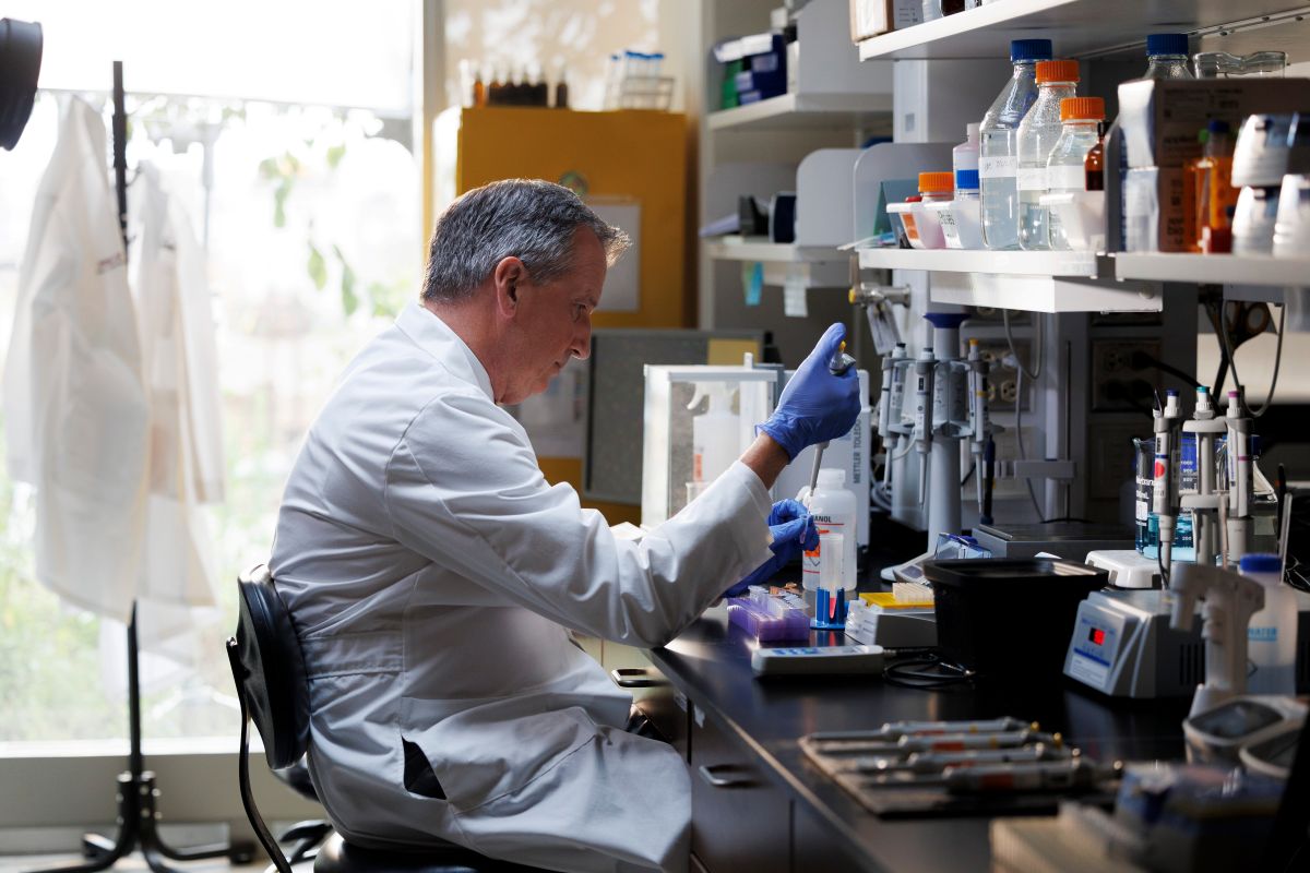 A faculty researcher conducts experiments in a lab