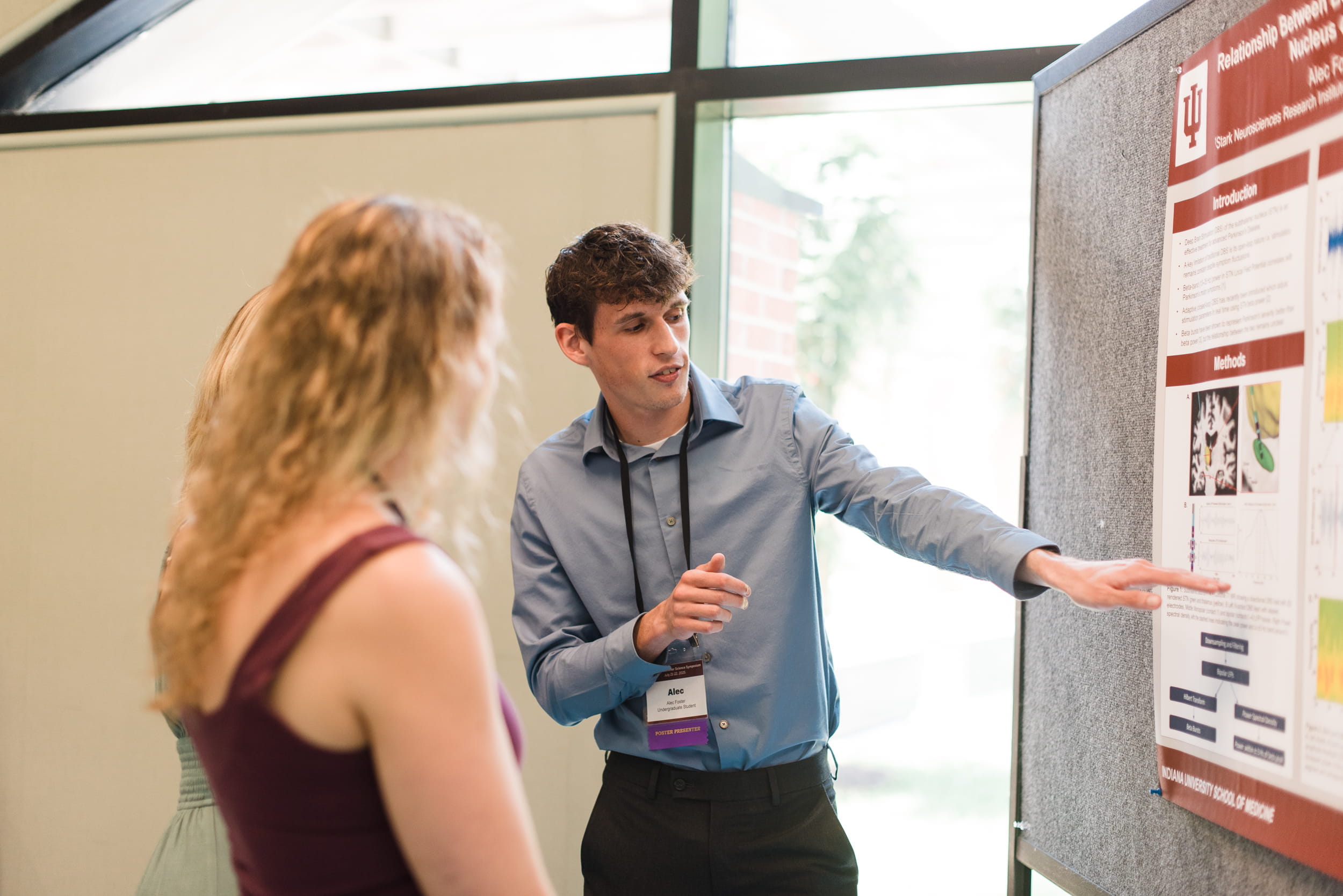A student talks at a poster presentation