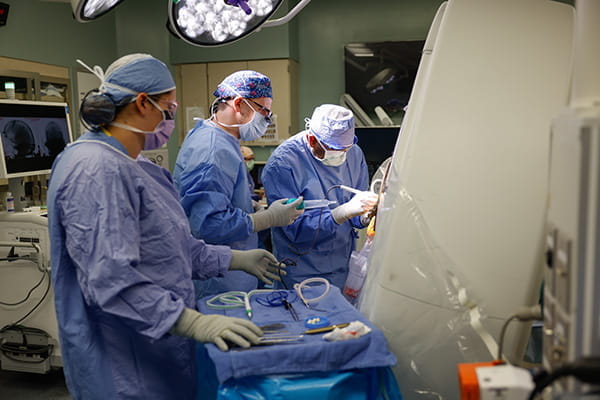 Dr. Purger in the OR with two others during DBS surgery