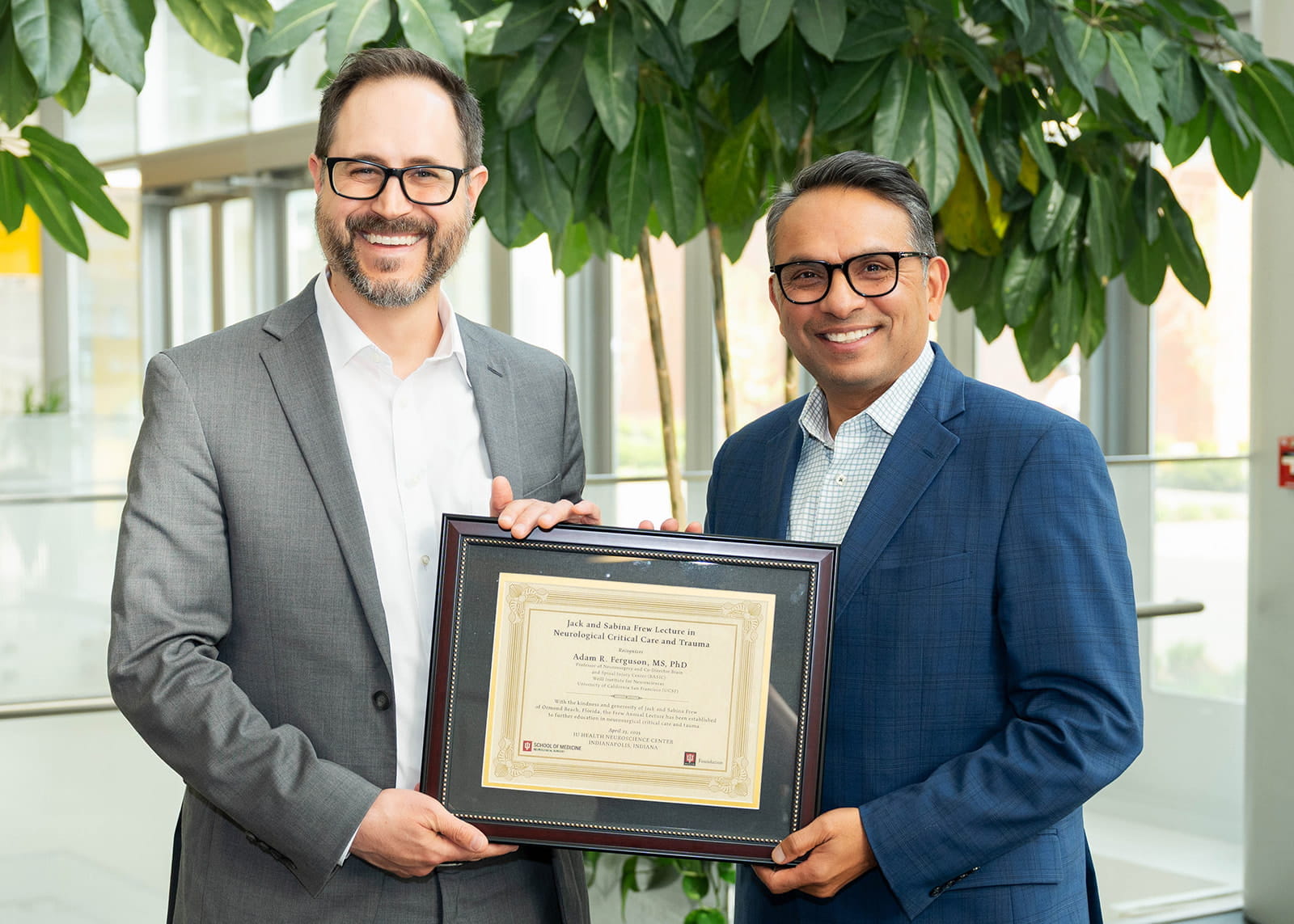 Dr.  Adam Ferguson with Dr. Mitesh Shah pose with a plaque