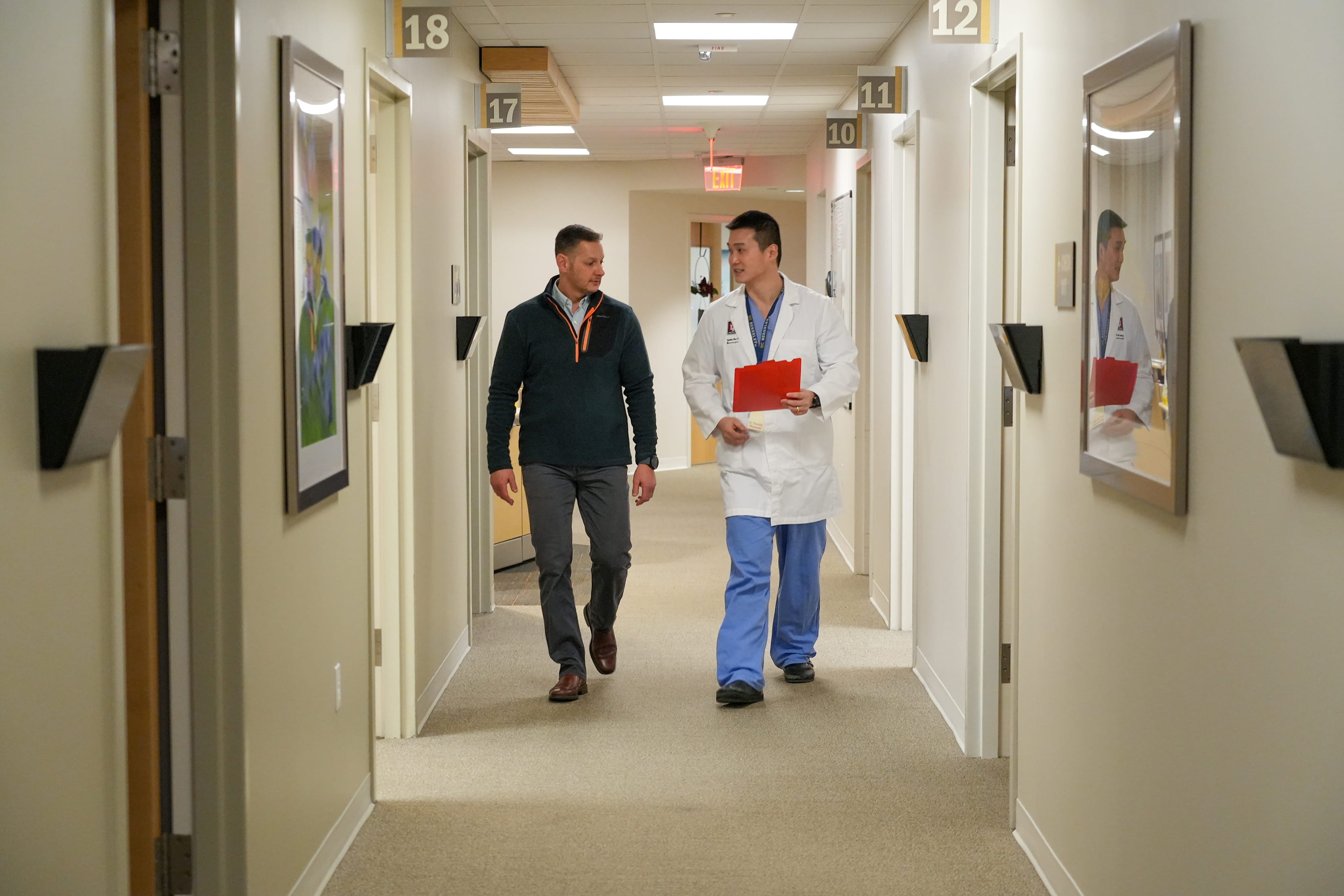 two people walk down the hallway in the neurosurgery clinic